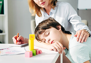 Bild zeigt schlafendes Kind und Betreuerin